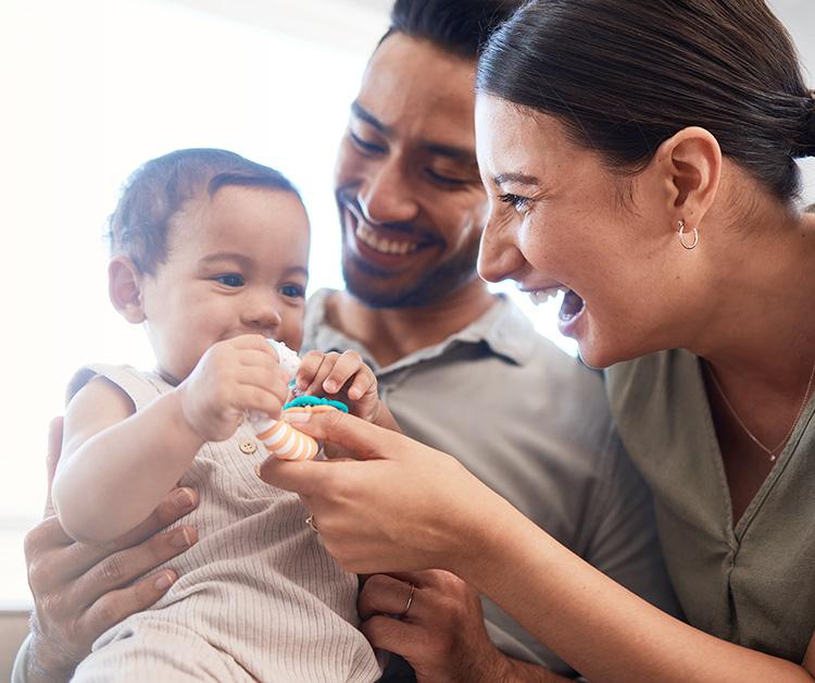 Two happy parents playing with their child
