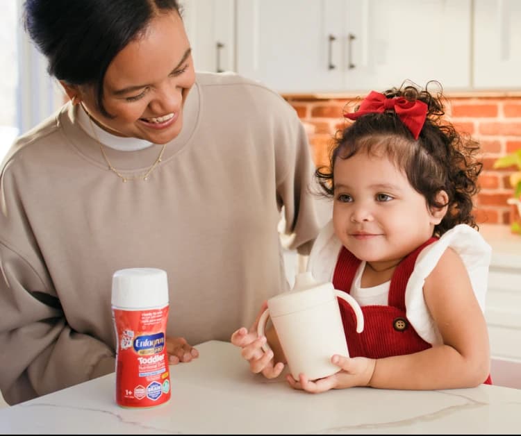 Happy toddler girl with her mom and Enfagrow Toddler