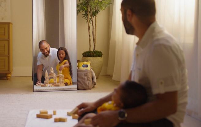Dad sitting in floor in front of mirror with baby