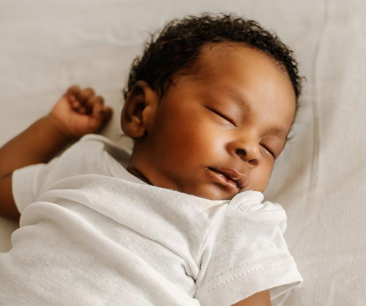 Close up of a baby sleeping on their back