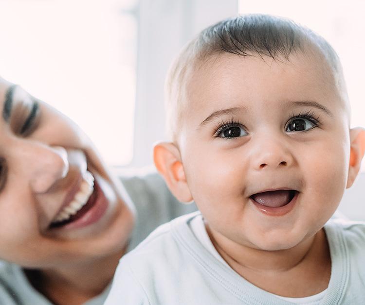 Mother and baby laying down, both smiling