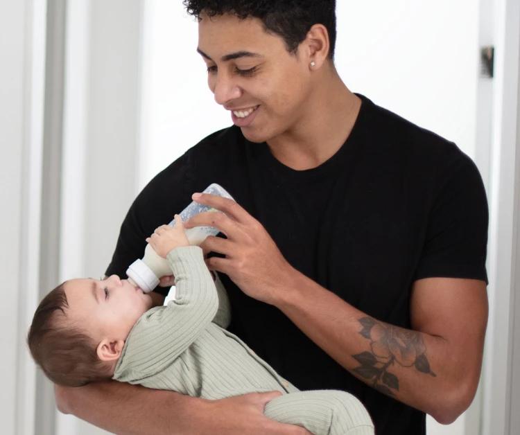 papá alimenta a su bebé con biberón