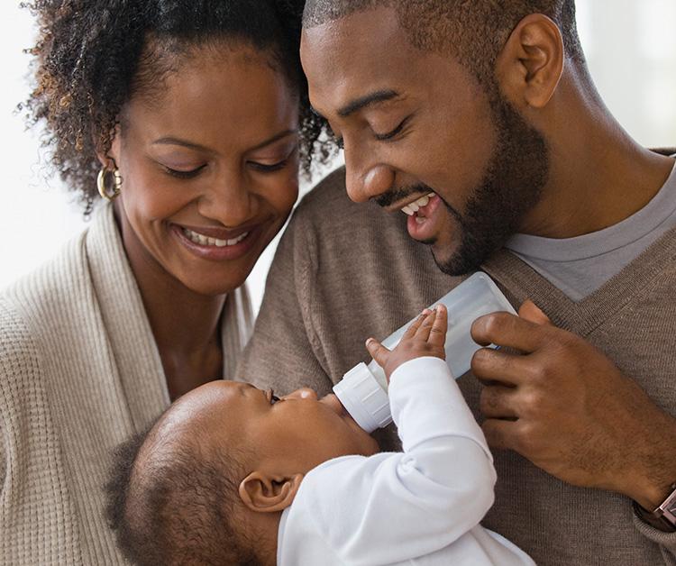 Mom bottle feeding her baby who is looking up at her