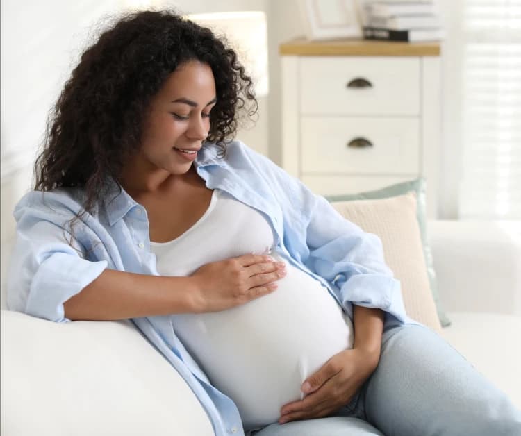 Una madre embarazada sentada en el sofá