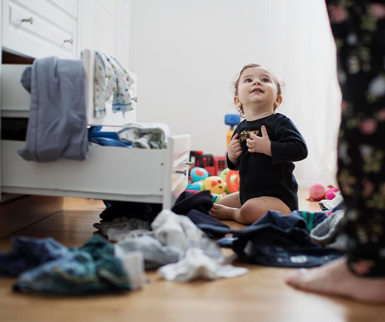 Baby sit in the floor rounded to clothes