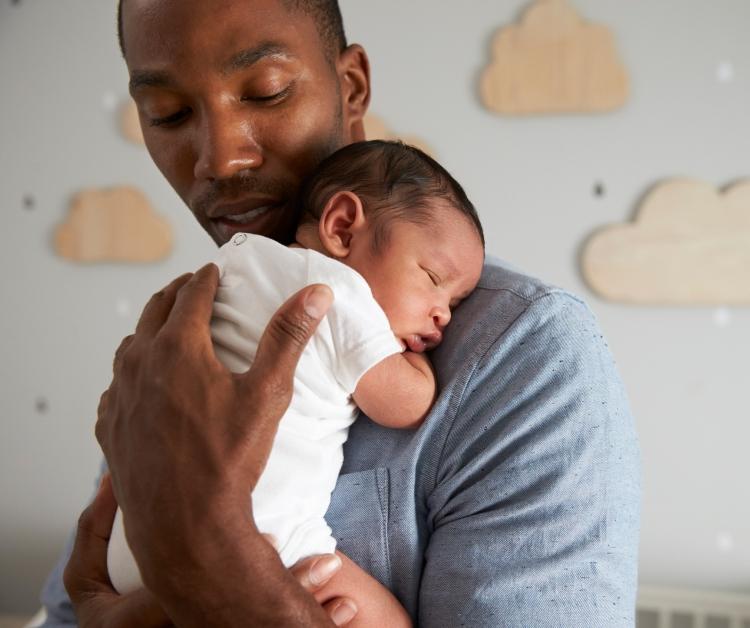 Papá sosteniendo al bebé en la guardería