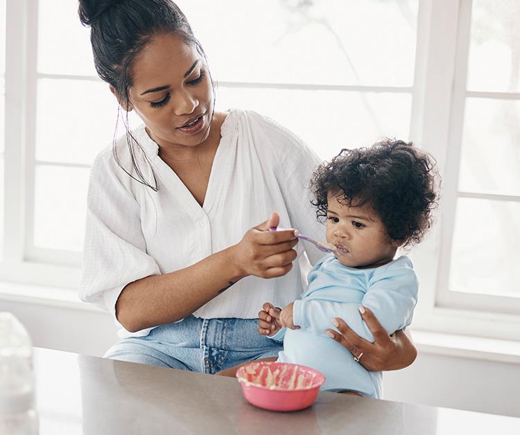Mom feeding toddler cereal