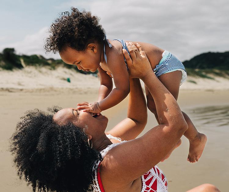 Mom and baby smiling on the beach