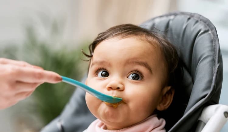Bebé siendo alimentado con cuchara