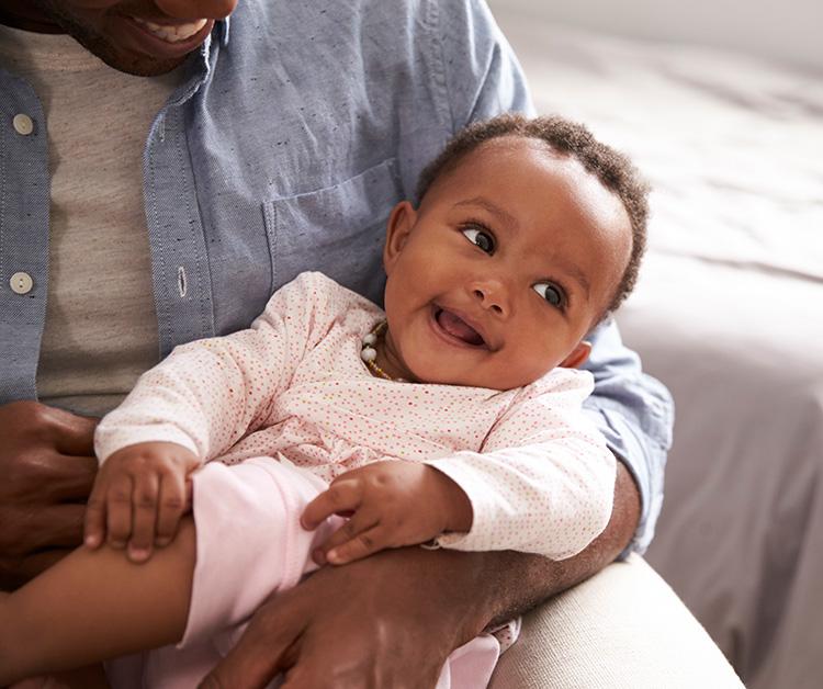 Dad holding his smiling baby girl