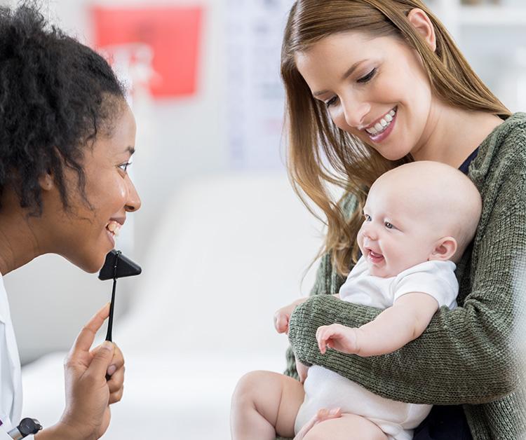 Mom holding her new baby at pediatrician appointment