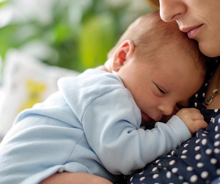 Preemie baby snuggling on mom's chest