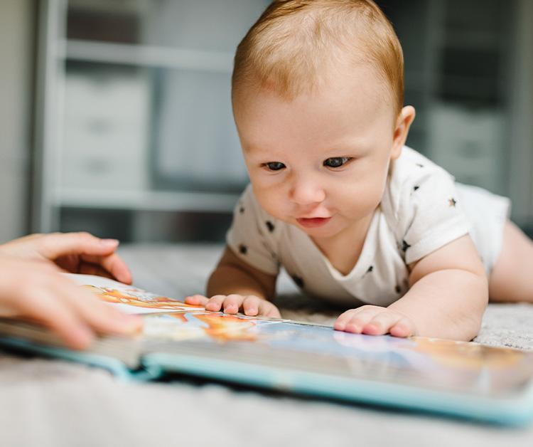 Baby on their tummy looking at a book