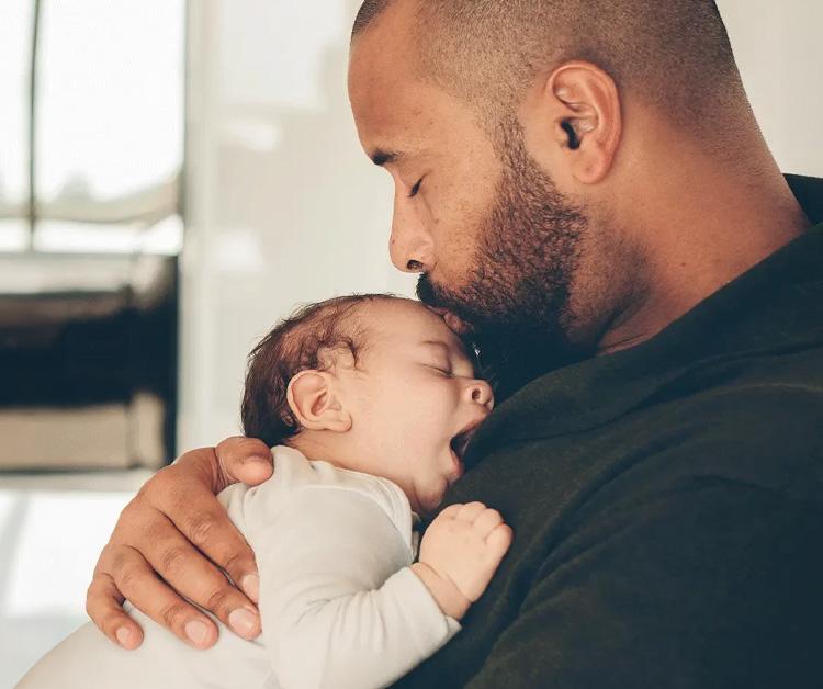 Papá sosteniendo al bebé dormido