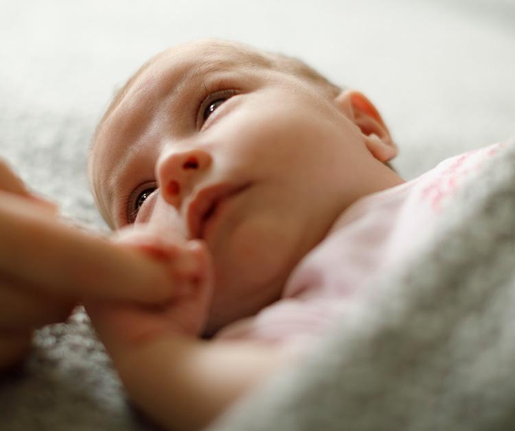 Newborn holding mom's finger