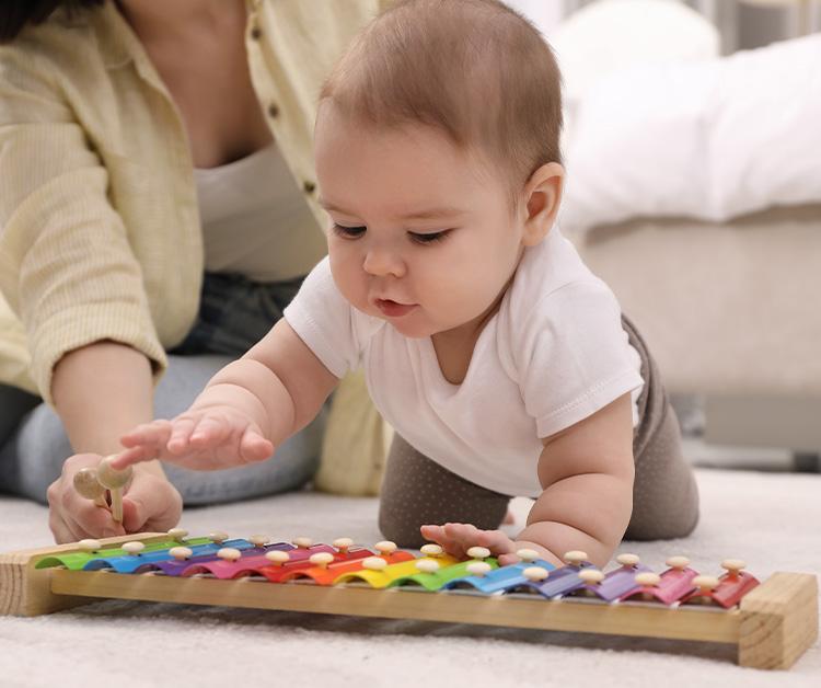 Los padres y el bebé en el suelo jugando con juguetes