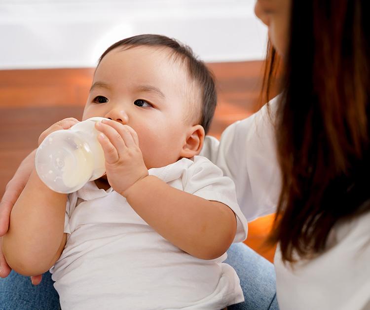 Mom holding baby as they drink a bottle