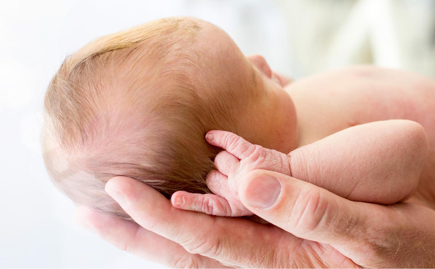 Parent Holding Newborn In Hands
